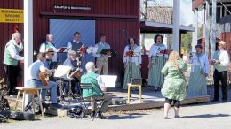 Yhteislaulutallennetta tekemässä Iin Laulupelimannien vetäjä Unto Kukka ja kitaristi Voitto Lepinoja (molemmat selin) sekä harmonikkaa soittava Esko Holappa ja kitaraa soittava Raimo Hentonen, seisomassa kontrabasisti Kalevi Sumen sekä laulajat Heikki Räinä, Ismo Piri, Jorma Kokko, Tuula Paakkola, Tuula-Riitta Niva, Maire Malo-Määttä ja Olavi Määttä. Riitta Räinä videoi. Julkaisemisen jälkeen tallenteet ovat netissä nähtävillä koko kesän.