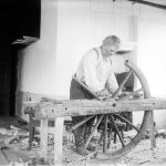 Hannusvaari tekee puista vaununpyörää vuonna 1913. Kuva: Museovirasto, kansantieteen kuvakokoelma, Samuli Paulaharjun kokoelma.