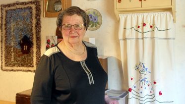 Kahdeksankymppisen Liisa Kääriän päivät täyttyvät ulkona liikkumisesta sekä käsitöistä. Taustalla näkyy pieni ryijy, jonka Liisan äiti aikanaan aloitti ja jonka Liisa juuri ennen koronaa sai viimeisteltyä. – Ryijy oli kääröllä ja siinä oli kaikki langat mukana, kun äiti sen minulle antoi. Vuosien aikana usein sen otin käsiini ja ajattelin, että mitä sille tekisin. Nyt se on vihdoin valmis! (Kuva: Teea Tunturi)