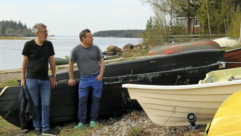 Jukka Ojala (vas.) ja Joni Siipola tutkailemassa venetilannetta Siikasaaren venevalkamassa. Asukasyhdistyksellä on selvitettävänä veneen omistajat, joiden odotetaan merkkaavan oman veneensä.