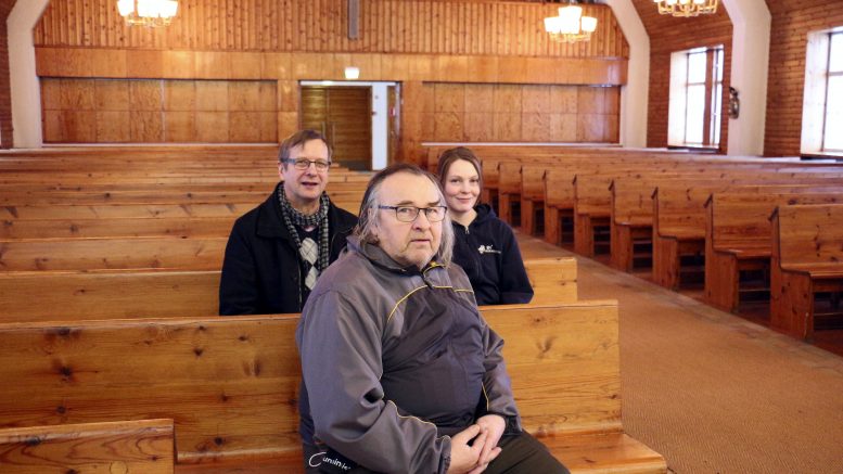 Vapaaehtoiset arkunkantajat Tauno Kivelä (edessä) ja Sauli Jaara sekä seurakuntamestari Anne Laurila kertovat vapaaehtoisten käytön arkunkantajina hautajaisissa käynnistyneen Iissä hyvin.
