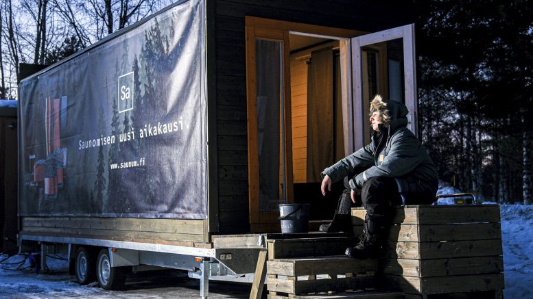 Saunavaunu on Iin Vihkosaaren uimarannalla niin, että sieltä voi käydä uimassa avannossa. Kuvassa Niko Ukkola, joka on toinen saunavaunuyrittäjistä. (Kuva Juho Tauriainen)