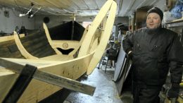 Kari Korpela rakentaa perheensä kanssa viikinkivenettä entisessä hevostallissa. Menossa on viimeisten sivulautojen asennus.