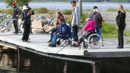 Etualalla onkivat Sirpa Kröger ja Sauli Lempiäinen, joka on jo kokenut kalamies, ja jonka idea kalaretken järjestäminen oli.Heistä ottaa kuvaa valkoiseen hattuun sonnustautunut Heidi Similä. Kuvassa myös osallistujien avustajia ja Iin Kalamiesten jäseniä, jotka opastivat onkijoita kalastuksen saloihin.