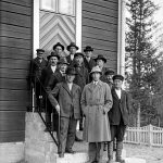 Miehiä Yli-Iin kirkon edustalla, sakastin portailla 1932. Edessä oikealla urakoitsijat Kujanpää ja Mannila. (Kuva: Museovirasto)