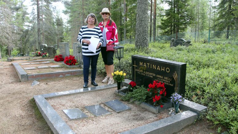 Hilkka Parkkisenniemi ja hänen siskonsa Eila Karjalainen Tannilan hautausmaalla heidän vanhempiensa haudalla. Perheen äiti, Anna Matinaho tuli evakkona Tannilaan 1939. Itsenäisyyspäivänä julkaistava kirja kertoo naisten elämästä kotirintamalla. (Kuva: Teea Tunturi)