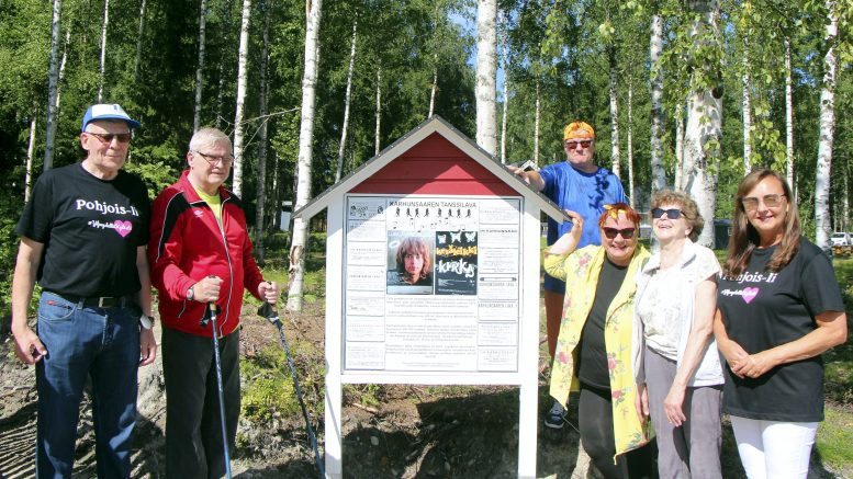 Pertti, Suke ja Tarmo Huovinen, Anita Sievänen, Maria-Liisa Halonen sekä Kaisu Sassi kerääntyneenä Karhunsaaren lavan muistotaulun ympärille.