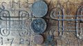 Kolmen kuninkaan uhrirahat” kuvattuna taikamerkein varustetun laudan päällä. Mukana lisäksi Aleksanteri II:n aikaiset pennit löytöpaikkana talon eteläisen nurkkakiven vierusta.