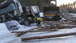 Olhavan suunnalta tulleen kuorma-auton kyydissä lavetin päällä ollut pyöräkuormaaja pysyi törmäyksestä huolimatta paikallaan. Kolarin toisena osapuolena ollut puutavararekka näkyy takana, ja sen perävaunusta purkautunut lasti tukki tien useiden kymmenien metrien matkalta.