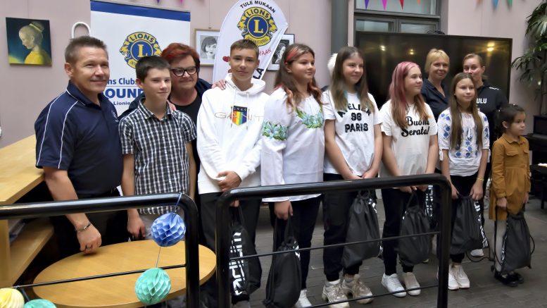 Lions I-piiri avustaa ukrainalaisia avustuspaketeilla ja tukee nuorten jalkapalloharrastusta. Kuvassa ukrainalaisia nuoria ja lionien Jari Hautala ja Eija Tuomaala (takana vas.) urheiluvälinekassien lahjoitustilaisuudessa.