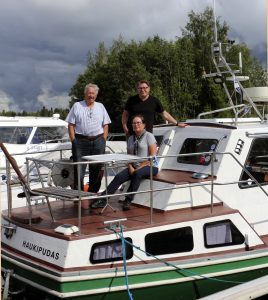 Pentti "Pena" Auranaho yhdessä Antti Vaselan ja Virpi Honkasen kanssa laivansa kannella, johon on kertynyt kilometrejä jo kahden maailmanympärysmatkat verran.