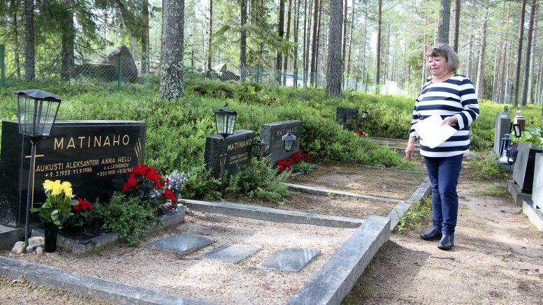 Hilkka Parkkisenniemi Tannilan hautausmaalla vanhempiensa haudalla kesällä 2022. Perheen äiti, Anna Matinaho tuli evakkona Tannilaan 1939. (Arkistokuva: Teea Tunturi)