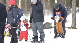 Pienten sarjassa vanhemmat tukivat pieniä hiihtäjien alkuja.
