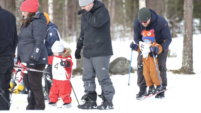 Pienten sarjassa vanhemmat tukivat pieniä hiihtäjien alkuja.