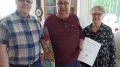 Kiimingin ja Ylikiimingin kuorma-autoilijoiden puheenjohtaja Pasi Leskelä (vas.) ja kultaisen ansiomerkin saanut Jukka Leppälä, vierellä puoliso Marja-Liisa Ojala. Kuvat: Kyösti Rasi.