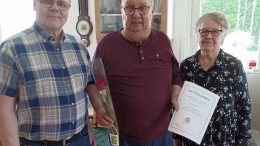Kiimingin ja Ylikiimingin kuorma-autoilijoiden puheenjohtaja Pasi Leskelä (vas.) ja kultaisen ansiomerkin saanut Jukka Leppälä, vierellä puoliso Marja-Liisa Ojala. Kuvat: Kyösti Rasi.