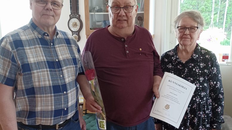 Kiimingin ja Ylikiimingin kuorma-autoilijoiden puheenjohtaja Pasi Leskelä (vas.) ja kultaisen ansiomerkin saanut Jukka Leppälä, vierellä puoliso Marja-Liisa Ojala. Kuvat: Kyösti Rasi.