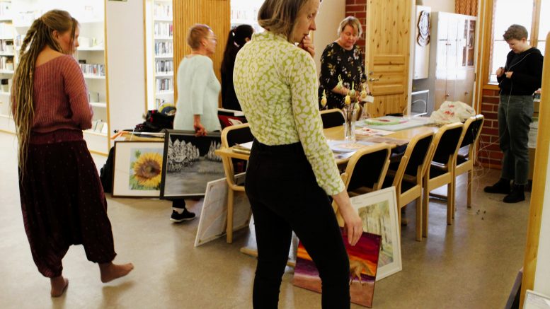 Näyttelyn pystytyksen alussa tauluja on joka puolella ja niiden sommittelu sekä yhteen sopivien töiden löytäminen ottaa aikansa. Edessä oikealla pohdiskelee Raakkel Ahola ja vasemmalla Merenven Rasmussen, taaempana taulu kädessään astelee Päivi Alakärppä. Pöydän takana teoksia tutkivat myös Katja Heinikoski ja Heli Heikkinen (oikealla). Kuva: Ritva Piri
