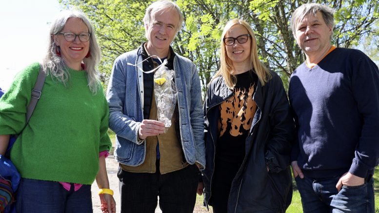 Kiviniemen satamaan valmistuvan taideteoksen tekee SUPERFLEX-taitelijaryhmä, johon kuuluva Rasmus Rosengren Nielsen sai Kellon asukastuvalta muistoksi käsityönä tehdyn ruusun. Vierellä taiteilijapari Tellervo Kalleinen ja Oliver Kochta-Kalleinen, jotka rakentavat yhteisöllisesti toista taideteosta Oravan koululla. Vasemmalla Climate Clock taidereitin kuraattori Alice Sharp. Kuva: Auli Haapala