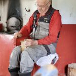 Matti Koistinaho jauhaa vieraalle kahvia lapsuudenkodin uunin ääressä, jonka muuraamisessa hän oli mukana, ja jonka hän kunnosti muutama vuosi sitten.