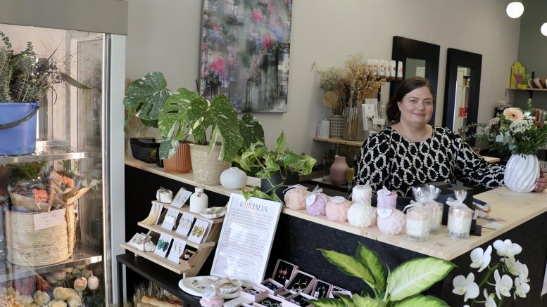 Laura Virtanen uudessa liikkeessään Jokelantien varrella. Liikkeessä on tilaa kukkakaupalle, kampaamopalveluille, sidontakursseille, käsin tehdyille koruille ja muille tuotteille sekä taidenäyttelylle. Taustalla seinällä näkyy Paula Vehkalahden maalaus. Kuvat: Auli Haapala