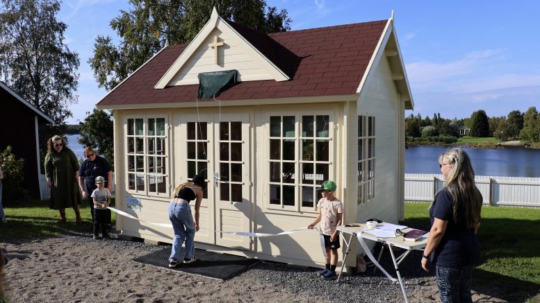 Emma leikkasi Hanneksen ja Valton pitelemän juhlanauhan pikkukirkon avaamisen kunniaksi. Vasemmalla kirkkoherra Ulla Mitrunen ja perhetyöntekijä Irmeli Hietapelto. Oikealla lastenohjaaja Minna Juntunen. Kuvat: Tuija Järvelä-Uusitalo