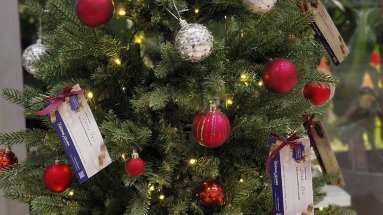 Kukkakauppa Sinituulen joulupuuhun Kiimingissä on ripustettu kortteja, jolla voi ilahduttaa ikäihmistä kukkatervehdyksen kera.