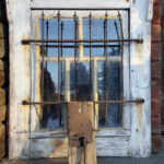 Avain, avainkilpi ja tukkilukko sekä taka-alan kalteri-ikkuna ovat puretuista sotavankien majoitustiloista. Kuva: Eino Mikkonen