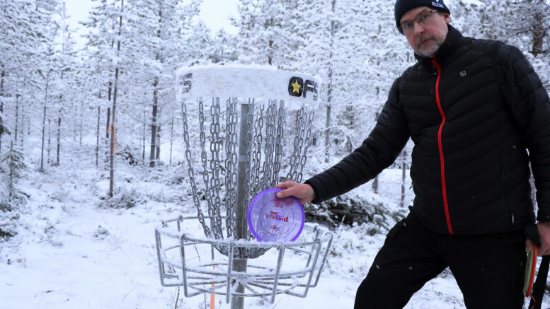 Jukka Tienhaara viimeistelemässä ja tarkistamassa frisbeegolfradan heittokoreja ja opasteita ennen avajaiskisoja. Vähäinen lumen määrä on lajille suotuisa. Annalankankaan rata tukee erityisesti uusien harrastajien, paikallisten asukkaiden ja nuorison liikuntamahdollisuuksia. Kuvat: Auli Haapala