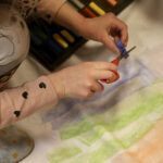 Lasten käsissä syntyy revontulten loimua.