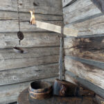 Pärepihti suutarin pihdin otteessa sekä karstakippo ja kettingissä riippuva traanilamppu. Kuva: Eino Mikkonen