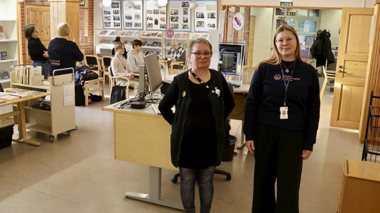 Yli-Iin kirjastovirkailija Ella Matinaho ja Oulu10-asiakaspalvelun palveluesihenkilö Matilda Liikanen toivovat, että yli-iiläiset tulevat rohkeasti tutustumaan palveluihin, joita Oulu10 kirjastolla tarjoaa. Kuva: Teea Tunturi