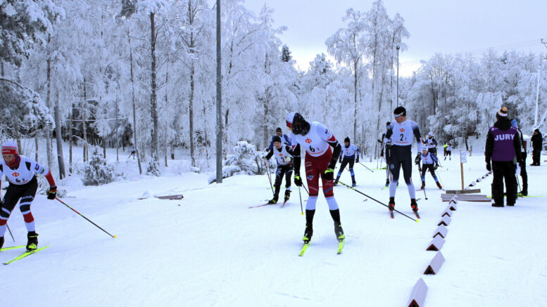 Ensimmäiseen vaihtoon saapui viisi joukkuetta aivan peräkkäin. Ensimmäisenä vaihtoi Kempeleen (nro 6) Petteri Lauren, joka lähetti matkaan Viljami Väyrysen. Takana Iin Taneli Pantsar (nro 2) siirtää viestin Atte Backmanille, ja välissä näkyy Oulun Veikka Sova (nro 1), joka hiihti kakkososuuden kovimman osuusajan ja toi siten joukkueensa ensimmäisenä seuraavaan vaihtoon. Kuvat: Ismo Piri