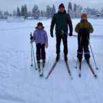 Hiihtokoululaiset Hilla ja Niklas Kukkola sekä hiihtokoulun opettaja Tapani Tuomikoski.