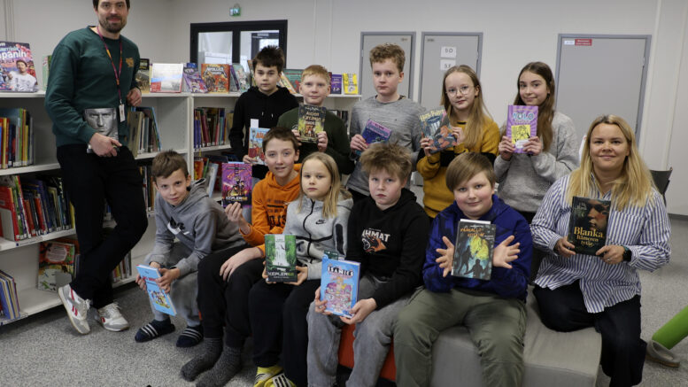 Kiviniemen koulun 5E-luokan oppilaita poikkesi koulun kirjastoon hakemaan lukemista talvilomalle. Luokan lukuprojektilla kerätään varoja luokkaretkeä varten, ja se innostaa oppilaita myös kirjojen pariin, kertovat luokanopettaja Ville Oksa ja vanhempien edustaja Anne Aspelund (oik.). Kuva: Auli Haapala
