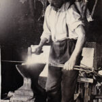 Viikatemestari Jaakko Heikkinen kallitsemassa viikatetta pajassaan Kiimingissä rautasillan korvassa. Jaakko oli taitava seppä. Etenkin hänen tekemät puukot olivat kuuluisia. Kuvanveistäjä, professori Oskari Jauhiainen piirsi sukulaismiehelleen Jaakolle puukon tupen mallin. Kuva Lauri Heikkinen.