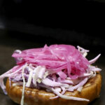 Lenny´sin oman keittiön coleslaw ja pikkelöity punasipuli raikastavat burgerin.