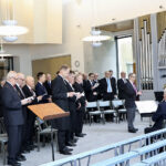 Päiväjuhlan aluksi laulettiin yhteislauluna Sillanpään marssilaulu Oulun NMKY:n puhallinyhtye Vaskiveikkojen säestäessä Mauri Kinnusen johdolla.