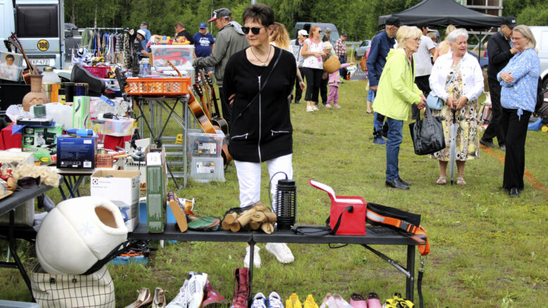Peräkärrykirppiksen tavarapaljouden keskellä saattoi katsella vaikkapa jotain, mitä asiakas ei vielä tiennyt edes tarvitsevansa. Kentälle syntyi myös lukuisia jutteluryhmiä tuttujen tavatessa toisiaan, usein pitkänkin ajan jälkeen. Kuvat: Ritva Piri