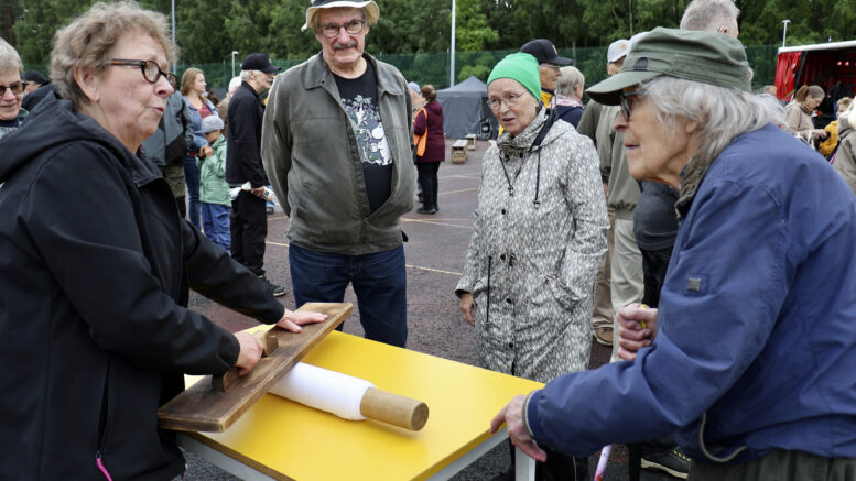 Maisa Ruokola esitteli entisajan pyykinpesua sekä mankelointia, jota kuvassa seuraavat Jorma ja Lahja Hanhela ja Raimo Mykkänen. Kuvat: Tuija Järvelä-Uusitalo